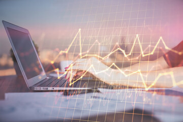 Double exposure of businesswoman hands typing on computer and forex chart hologram drawing....