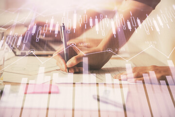 Multi exposure of woman hands typing on computer and financial chart hologram drawing. Stock market...