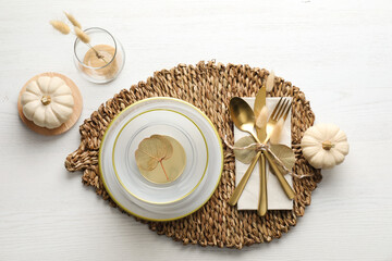 Autumn table setting with pumpkins on white wooden background, flat lay