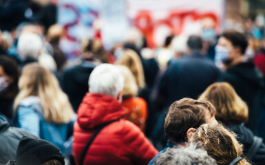 Rear view of Large crowd of people with mask in central square of a French city during a protest