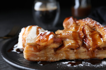 Slice of traditional apple pie with ice cream on plate, closeup