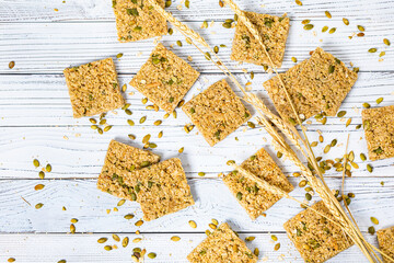 Multigrain Cereal Crunchy Squares Bars with Pumpkin Seeds on Wooden Background. Selective focus.