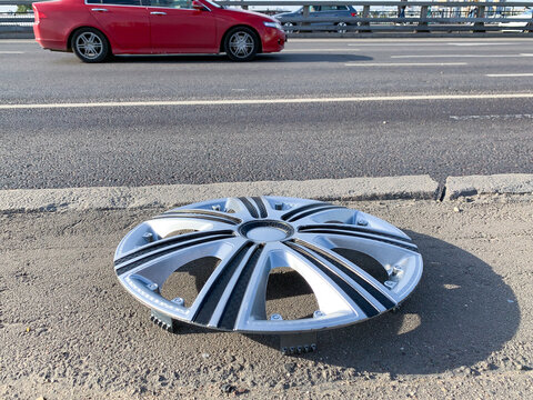 Lost hubcap on the side of a city road