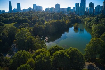 Obraz premium Panoramic aerial shot of the famous Piedmont park and Lake Clara meer with Atlanta skyline in background shot during golden hour by a drone