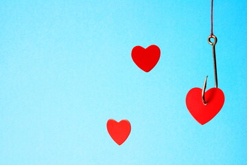 Heart on a hook on a blue background. Concept of love. Valentine's day. Love choice.