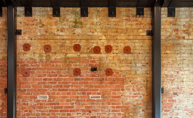 Old red brick wall with new steel reinforcement structure for restoration