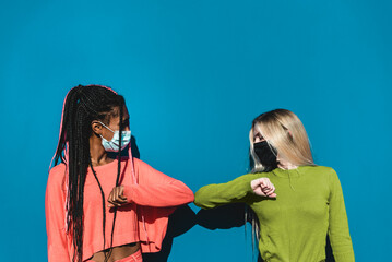 Young multiracial friends elbow greeting to avoid the spread of coronavirus instead of greeting...
