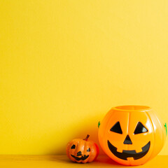 Halloween pumpkins on table with yellow copy space
