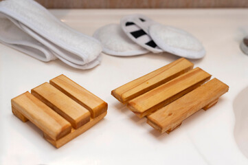 Modern and ecological wooden soap holder on bathroom countertop, along with reusable cleaning pad.