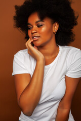 Fototapeta na wymiar pretty young african american woman with curly hair posing cheerful gesturing on brown background, lifestyle people concept