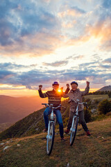 Fototapeta premium Happy senior couple riding bicycles at park and raising hands
