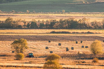 Lonely tractor harvest hay field crop stubble golden yellow orange autumn mountain background massive bulgaria technology machine agriculture