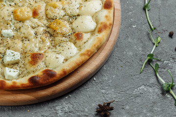 four cheese pizza, italian pizza. pizza stuffed with four varieties of cheese on a gray background.