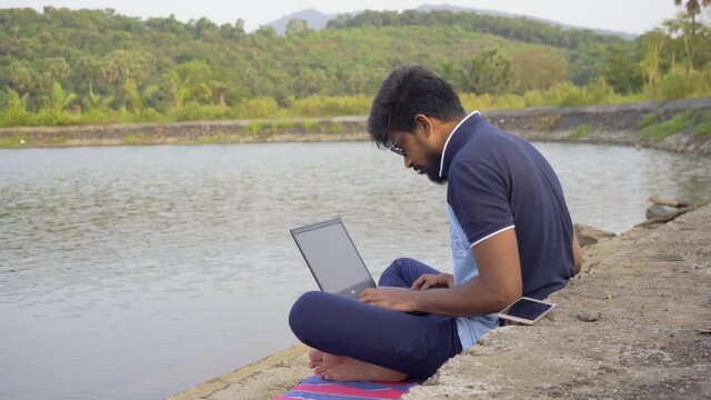 wokring remotely from laptop  loaction lake side india new normal.