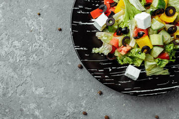 Greek Salad with Cucumeber, Kalamata Olives, Feta Cheese, Juicy Cherry Tomatoes and Fresh Basil. Concept for a tasty and healthy vegetarian meal