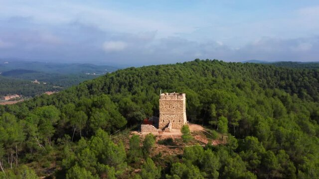 aerial drone shot of soldiers tower in aviny&oacute; dense natural green forest. mountains of catalonia spain.