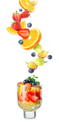Delicious fruit salad in glass and flying ingredients on white background