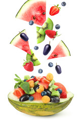 Delicious fruit salad in melon bowl with flying ingredients on white background