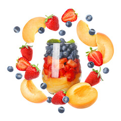 Delicious fruit salad in glass and flying ingredients on white background
