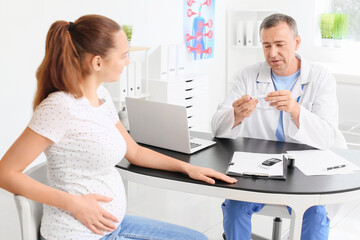 Fototapeta premium Pregnant diabetic woman visiting doctor in clinic