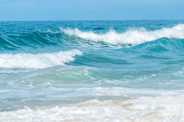 Fototapeta premium Travel vacation background, at summer beach, with sunny sky, Water wave splash on blue sea background., at summer beach, with sunny sky, Water wave splash on blue sea background.