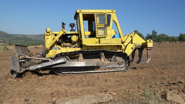 Earthworks Dozer (Bulldozer) Excavator in mountainous terrain, land correction and field clearing
