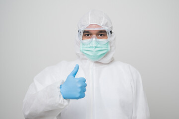 A portrait of virologist Wearing PPE suit get thumb up and look into cabers isolated on white background. Personal Protective Equipment Concept..