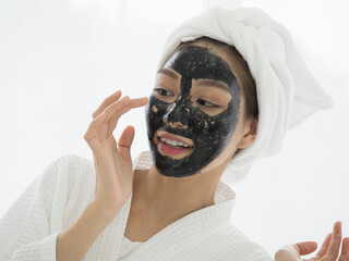 Portrait of Young woman relaxing with facial masks on white background