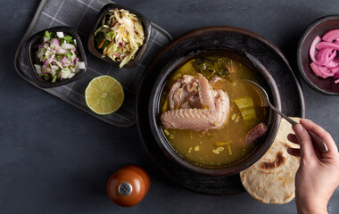 Traditional salvadoran hen soup served with lemon, onion and corn tortillas, latin america food