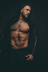 Muscular guy with sexy torso on black. Athletic young man showing his perfect naked body.