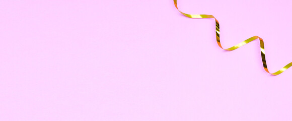 Golden ribbons isolated on pastel pink background
