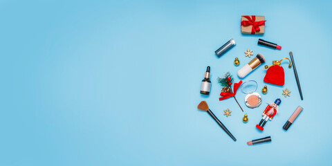 banner.Christmas tree balloon made of toys and cosmetics on a blue background.Gift,balloons, snowflakes, lipstick, blush and brushes.Holiday Background.flatly, greeting card with copy space