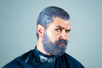 Men hair color. Bearded guy in barbershop colored hair beard and moustache. Serious male face...
