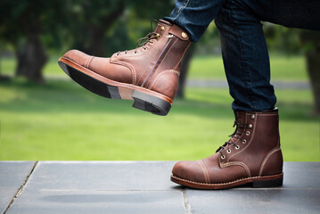 Fashion men s legs in blue jeans and brown boots with zipper for man collection.