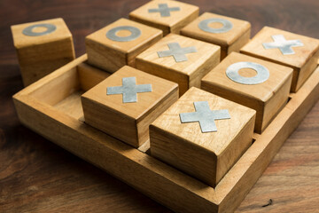 Fun concept. Playing a Game of Tic Tac Toe with wooden pieces on a wooden background - obrazy, fototapety, plakaty