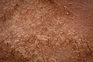 Top view cracked red soil. Picture of natural disaster. Drought land, global warming and deforestation. Image of brown soil texture, close up. Desert realistic background.