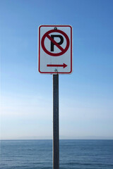 NO PARKING sign at a street along the ocean beach