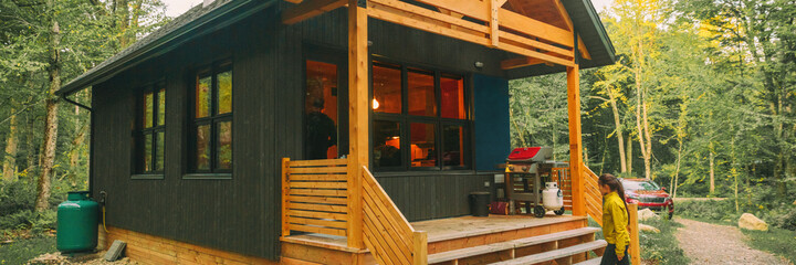 Vacation rental forest lodge countryside cabin by the lake for holidays in the wilderness. Woman...