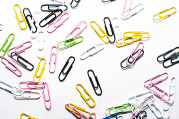 multi-colored paper clips on a white background