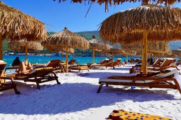 Bodrum, Turkey - August, 2020: Snow-white beach of Lux Hotel with emerald water of Aegean Sea. Yachts.People sunbathing on the beach. Sunbeds on the beach. Relaxing Deluxe Leisure Conception