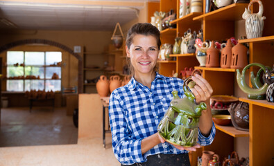 Fototapeta premium Positive female artisan having ceramics in workshop. High quality photo
