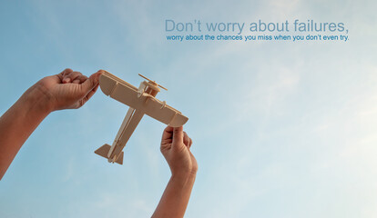 Motivational quotes, Happy kid playing with toy wooden airplane against sunset sky background. - obrazy, fototapety, plakaty