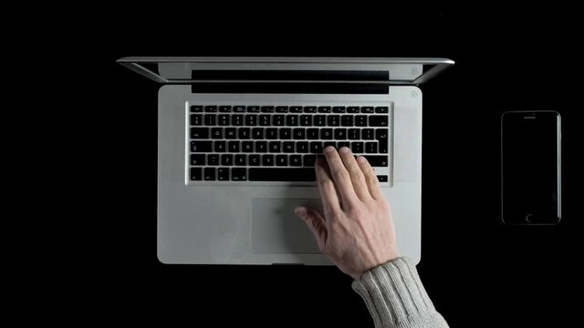 A man working on a laptop online from his home. Top down view.