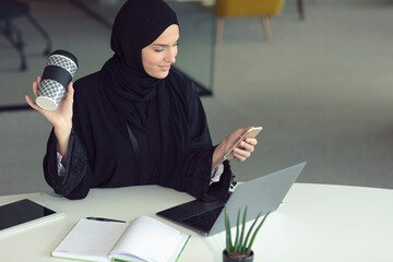 professional young muslim business woman using mobile digital tablet computer at work