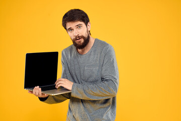 man with laptop wireless technology internet lifestyle work yellow isolated background