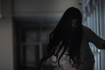Horror evil woman ghost creepy in a dark room at house. The female devil is scary she haunted at...