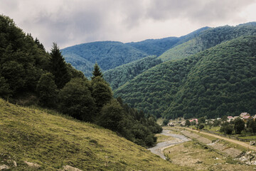 Mountain river among the hills in the blue haze. Rural measured life concept.