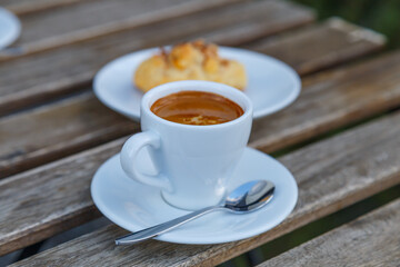 Cup of coffee on table in coffee shop cafe.A cup of coffee and coffee beans with croissant on the table