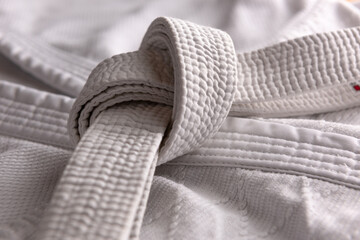 White judo, aikido, or karate belt, tied in a knot on white kimono © marritch