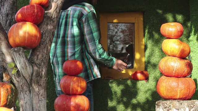 The man decorates the house with pumpkins.